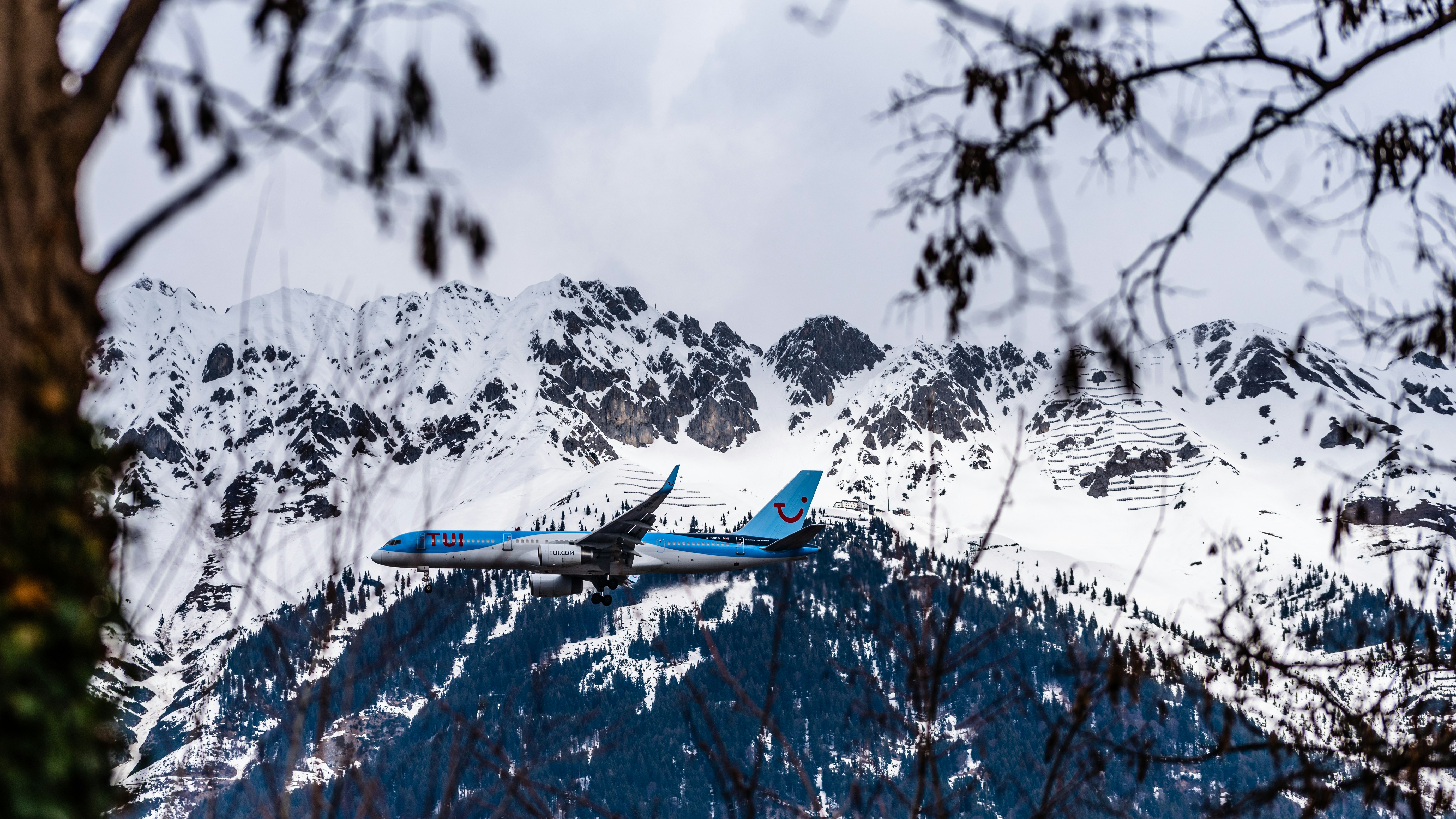 blue and white airplane over mountains